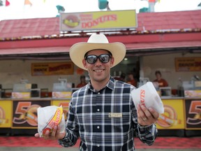 Kyle Corner, manager programming entertainment with the Calgary Stampede, holds mini donuts infront of their stand celebrating 50 years at the Stampede on Friday July 6, 2018. Leah Hennel/Postmedia