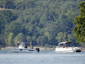 Emergency workers patrol an area Friday, July 20, 2018, near where a duck boat capsized the night before resulting in at least 17 deaths on Table Rock Lake in Branson, Mo.