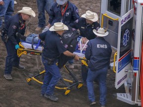 Chuckwagon driver Obrey Motowylo taken off the field after falling from the wagon seat in Heat 8 at the Calgary Stampede in Calgary, Ab., on Tuesday, July 10, 2018.