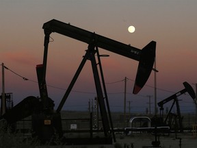 FILE - In this June 8, 2017, file photo, oil derricks are busy pumping as the moon rises near the La Paloma Generating Station in McKittrick, Calif. The U.S. is on pace to leapfrog both Saudi Arabia and Russia as the worldís biggest oil producer. (AP Photo/Gary Kazanjian, File) ORG XMIT: NYAG306