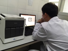 In this May 7, 2018, photo, a staffer works at a laptop next to an American-made GeneXpert machine used to diagnose tuberculosis at the National Tuberculosis Reference Laboratory in Pyongyang, North Korea. The machines at the lab can't be used because officials can't procure the materials they need to operate them. Despite a mood of detente following the summit between U.S. President Donald Trump and North Korean leader Kim Jong Un in June, ongoing sanctions are keeping life-saving medicines from North Korean tuberculosis patients and could fan a regional epidemic.