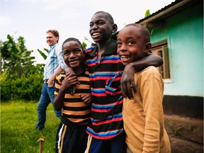 Two clients of Kyaninga Child Development Centre pose with their friend outside their home, as mom Kemisiga Rose and Steve Williams of KCDC look on. Courtesy of Kevin Brown, Mighty Ally. Fortney Day 2.
