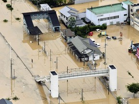 Buildings are partially submerged by floodwaters caused by heavy rains in Kure, south western Japan, Saturday, July 7, 2018. Torrents of rainfall and flooding continued to batter southwestern Japan.