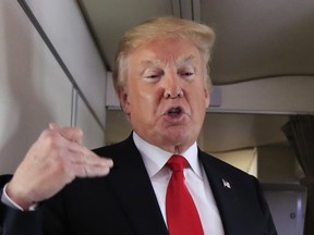 U.S. President Donald Trump speaks to reporters onboard Air Force One Friday, June 29, 2018, on his way to Bedminster, N.J.