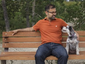Shaneel Pathak and his dog Zoey sit on a bench overlooking the Elbow River at the River Park dog park on Saturday, Aug. 11, 2018, where him and his late wife, Heing, used to sit together. Pathak will cycle over 200-km in The Ride to Conquer Cancer to honour his late wife who lost her battle with lung cancer this past November.
