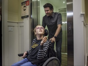 Clare Jackson rides the elevator in her new residence, a specialty-built accessible home by Cardel Homes. The home was unveiled to the media on Friday, Aug. 24, 2018. Kerianne Sproule/Postmedia Calgary