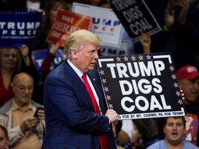 Republican presidential nominee Donald Trump holds a sign supporting coal during a rally at Mohegan Sun Arena in Wilkes-Barre, Pennsylvania on October 10, 2016.