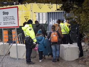 A family, claiming to be from Colombia, is arrested by RCMP officers as they cross the border into Canada from the United States as asylum seekers near Champlain, N.Y., on April 18, 2018.