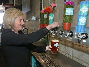 Alberta Premier Rachel Notley pulls a glass of beer at the Cold Garden Brewery after touring the Inglewood business on March 27, 2017.