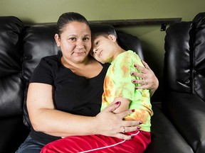 Tammy Covino cradles her eight-year-old son Ryken, who has a rare form of leukemia.