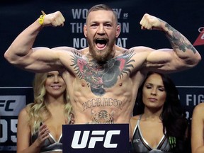 In this Friday, Nov. 11, 2016, file photo, Conor McGregor stands on a scale during the weigh-in for his fight against Eddie Alvarez in UFC 205 at Madison Square Garden in New York. (AP Photo/Julio Cortez, File)