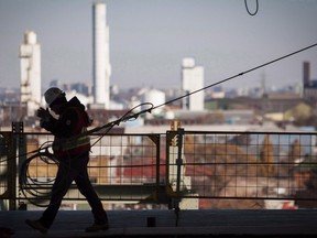 A worker walks on a construction site in Hamilton, Ont., on November 14, 2013. A rush of new part-time jobs offset a drop in full-time work last month to help Canada post a net gain of 54,100 positions and drop the national unemployment rate down to a four-decade low.