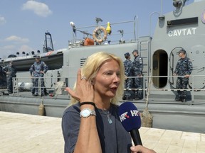 In this photo taken Aug. 19, 2018, a woman who identified herself as Kay from England, is interviewed by local media in front of a Croatian Coast Guard vessel in the port in Pula, Croatia.