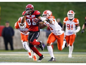 BC Lions' Otha Foster III, right, grabs onto Calgary Stampeders' Kamar Jorden, during second half CFL football action in Calgary on Saturday. Photo by Jeff McIntosh/The Canadian Press.