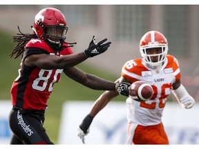 BC Lions' Anthony Orange, right, lloks on as Calgary Stampeders' Marken Michel, misses a catch during first quarter CFL football action in Calgary, Saturday, Aug. 4, 2018.THE CANADIAN PRESS/Jeff McIntosh ORG XMIT: JMC104