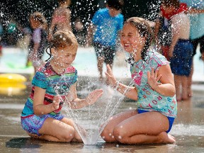 Sienna Henderson (left), 8, and Taylor Olesko, 9, cool down at the Bowness Park wading pool as the heat wave continues in Calgary.