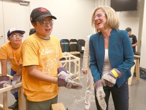 Premier Rachel Notley (R) dons safety gloves during a visit to Telus Spark in Calgary on Friday, August 3, 2018. The Premier joined students from the Tinkering, Tools and Tech camp and the Junior Scientists Camp. Jim Wells/Postmedia
