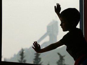 Andres Cortes peers out the window on Thursday, Aug. 16, 2018, at Canada Olympic Park's Winsport, where he is attending a soccer camp. Winsport has had to keep kids busy with indoor activities as smoke from B.C. wildfires settles over Calgary.