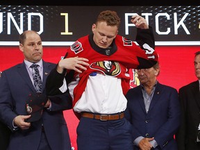 Brady Tkachuk puts on an Ottawa Senators jersey after being selected by the team during the NHL hockey draft in Dallas on June 22, 2018. The Ottawa Senators have signed forward Brady Tkachuk to a three-year, entry-level contract.The 18-year-old St. Louis native was selected fourth overall by Ottawa in the first round of last month's NHL draft.