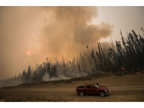 Verne Tom stops to check on a wildfire burning on a logging road approximately 20km southwest of Fort St. James, B.C., on Wednesday, August 15, 2018.