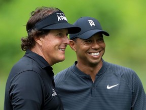 Phil Mickelson, left, and Tiger Woods smile during a practice round prior to the World Golf Championships-Bridgestone Invitational at Firestone Country Club in Akron, Ohio on on August 1, 2018.