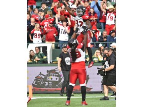 Calgary Stampeders Randy Richards (59) lifts up Romar Morris (32) in celebration after scoring a touchdown against the Edmonton Eskimos  during CFL action at Commonwealth Stadium in Edmonton, September 8, 2018. Ed Kaiser/Postmedia