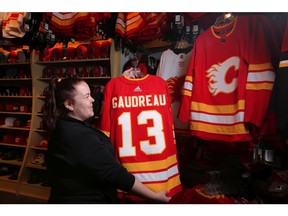 Toni Lavallee, sales associate at FanAttic, stocks the store with the new Calgary Flames third jerseys at Scotiabank Saddledome in Calgary, on Friday September 21, 2018. Leah Hennel/Postmedia