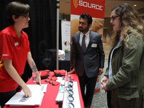 Tim Amin, 23 and Rana Kadri, 20, speak with Leandra Curran, Source assistant manager, left, during the Hiring Fair at City Hall in Calgary on Friday September 28, 2018. Leah Hennel/Postmedia