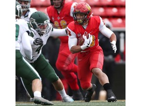 Calgary, AB - September 29, 2018. University of Calgary #33 Robinson Rodrigues looks for open space and eludes  pressure from University of Saskatchewan Huskies # 4 Ben Whiting. The Dinos defeated the Huskies 33-13 Saturday afternoon at McMahon Stadium during Canada West football action.  Photo by David Moll / Dinos Digital Media