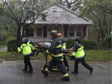 WILMINGTON, NC - SEPTEMBER 14:  Rescue personnel remove a man from a home that a large tree fell on that had three people trapped after Hurricane Florence hit the area, on September 14, 2018 in Wilmington, North Carolina. One man was taken out of the home in critical condition, and the condition of two others is unknown. Hurricane Florence hit Wilmington as a category 1 storm causing widespread damage and flooding along the Carolina coastline.