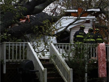 WILMINGTON, NC - SEPTEMBER 14:  Firefighters arrive at a home where a large tree fell on that had three people trapped, after Hurricane Florence hit the area, on September 14, 2018 in Wilmington, North Carolina. One man was taken out of the home in critical condition, and the condition of two others is unknown. Hurricane Florence hit Wilmington as a category 1 storm causing widespread damage and flooding along the Carolina coastline.