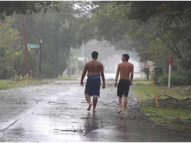 NORTH MYRTLE BEACH, SC - SEPTEMBER 14:  Xavier Worriax (L) and David Abraham walk through the rain and wind as Hurricane Florence is felt through the area on September 14, 2018 in North Myrtle Beach, United States. Hurricane Florence is hitting along the North Carolina and South Carolina coastline bringing high winds and rain.