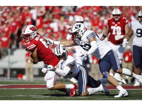 MADISON, WI - SEPTEMBER 15: Chris Wilcox #32 and Isaiah Kaufusi #53 of the BYU Cougars make a tackle against Danny Davis III #6 of the Wisconsin Badgers in the first quarter of the game at Camp Randall Stadium on September 15, 2018 in Madison, Wisconsin. BYU won 24-21.