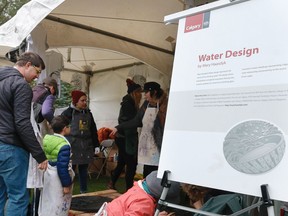 Volunteers for the Alberta Printmaking Society help event-goers print one of three new City of Calgary manhole designs on a t-shirt or canvas bag at Prince's Island Park on Saturday, Sept. 15, 2018. The designs were created by Canadian artists; Andrea Williamson, Mary Haasdyk and Jeff Kulak. Kerianne Sproule/Postmedia Calgary