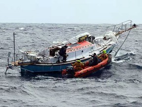 In this photo provided by the Australian Maritime Safety Authority on Tuesday, Sept. 25, 2018, Indian sailor Abhilash Tomy, left, transfers to an inflatable boat as rescuers collect him from his damaged yacht, Thuriya, in the southern Indian Ocean. Tomy was injured and his yacht lost its mast in a storm on Friday.