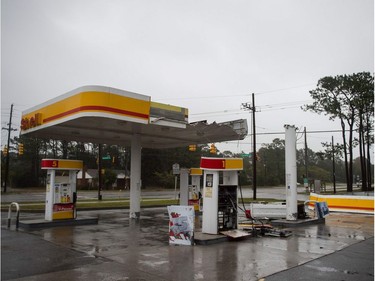 The roof of a gas station is destroyed from strong winds as Hurricane Florence passes over Wilmington, North Carolina on September 14, 2018. - Florence smashed into the US East Coast Friday with howling winds, torrential rains and life-threatening storm surges as emergency crews scrambled to rescue hundreds of people stranded in their homes by flood waters. Forecasters warned of catastrophic flooding and other mayhem from the monster storm, which is only Category 1 but physically sprawling and dangerous.