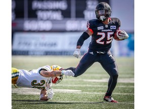 Calgary Stampeders Don Jackson avoids a tackle by Aaron Grymes of the Edmonton Eskimos during the Labour Day Classic in Calgary on Monday. Photo by Al Charest/Postmedia