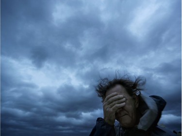 Russ Lewis covers his eyes from a gust of wind and a blast of sand as Hurricane Florence approaches Myrtle Beach, S.C., Friday, Sept. 14, 2018.