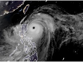 A satellite image with land graphic borders shows the width and trajectory of Super Typhoon Mangkhut as it approaches the Philippines, Friday. Typhoon Mangkhut retained its ferocious strength and shifted slightly toward more densely populated coastal provinces on Friday as it barreled closer to the northeastern Philippines, where a massive evacuation was underway. (RAMMB and CIRA via AP)