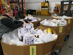 Jen Little with the Calgary Food Bank helps with the organization of some of the thousands of pounds of food donated during a city-wide food drive. Bins of donated food began arriving at the food bank on Saturday  September 15, 2018.  Gavin Young/Postmedia