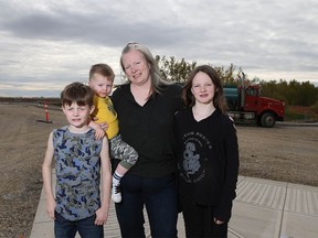 Chrissy Craig, poses with her three kids (L-R) Connor, 8 yrs, Kyle, 2, and Sarah, 10 yrs in Langdon, about 35 km east of Calgary, on Wednesday, September 26, 2018. They are posed at the edge of the property where the school was planned. A proposed high school in the hamlet has been put on the backburner again. Jim Wells/Postmedia