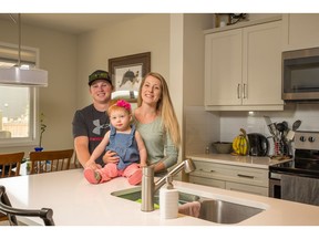 Jocelyn and Cody Edwards with Emery their new home by Homes by Dream in Montrose High River.