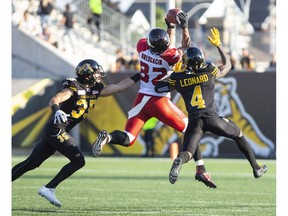 Calgary Stampeders wide receiver Juwan Brescacin makes the catch as Hamilton Tiger-Cats defensive back Mike Daly and Richard Leonard defend during CFL action Saturday in Hamilton.