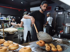 Jiten Grover, owner of Dipped Donuts, prepares a new batch of donuts after nearly selling out by the afternoon in Toronto on Wednesday, Sept. 12, 2018.