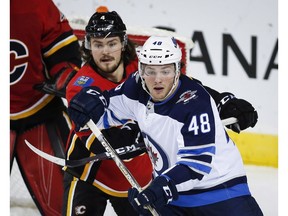Winnipeg Jets' Brendan Lemieux, right, and Calgary Flames' Rasmus Andersson, of Sweden, struggle for position during preseason NHL hockey action in Calgary, Monday, Sept. 24, 2018.THE CANADIAN PRESS/Jeff McIntosh ORG XMIT: JMC105