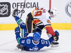Calgary Flames' Dillon Dube (59) checks Vancouver Canucks' Kole Lind (78) during the second period of a pre-season NHL hockey game in Vancouver, B.C., on Wednesday September 19, 2018. THE CANADIAN PRESS/Darryl Dyck ORG XMIT: VCRD113