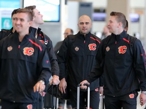 Calgary Flames captain Mark Girodano, centre, walks with teammates from left; Mikael Backlund, Mark Jankowski and Brett Kulak at the Calgary International Airport before boarding a charter flight to Shenzhen, China on Tuesday September 11, 2018. The team will play two exhibition games against the Boston Bruins in China.  Gavin Young/Postmedia
