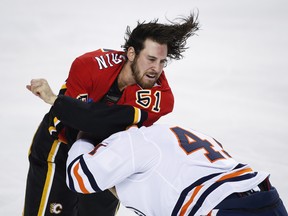 Edmonton Oilers' Evan Polei, right, fights with Calgary Flames' Scott Sabourin during first period preseason NHL hockey action in Calgary, Monday, Sept. 17, 2018.THE CANADIAN PRESS/Jeff McIntosh ORG XMIT: JMC103