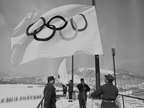 FILE - In this Jan. 23, 1972, file photo, members of Japan's self-defense ground forces raise Olympic Flags in Sapporo at Makomanai speed skating stadium in a rehearsal of ceremony at the official opening of Winter Olympic. The Japanese city of Sapporo is expected to withdraw from bidding for the 2026 Winter Olympics. This would leave four candidates as the International Olympic Committee finds it increasingly difficult to find hosts, particularly for the Winter Olympics. The IOC will name the winning bidder a year from now. The four remaining are: Stockholm, Sweden; Calgary, Canada; Turin, Milan, and Cortina d'Ampezzo, Italy; Erzurum, Turkey. (AP Photo, File)