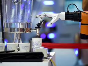 A robot arm collects a cup of water at the 2018 World Robot Conference in Beijing on Aug. 15, 2018.